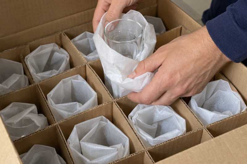 Verres emballés dans du papier et rangés dans un carton à cases