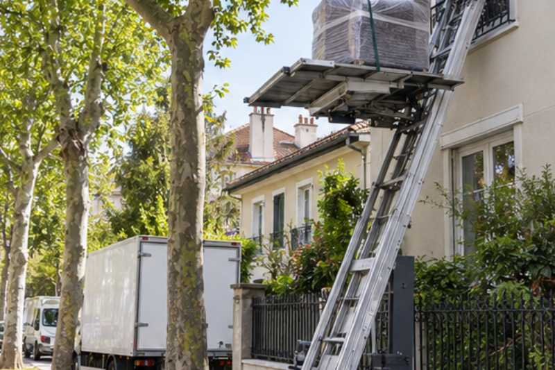 Monte-meuble déployé contre la façade, un fauteuil emballé sur la plateforme, Alfortville