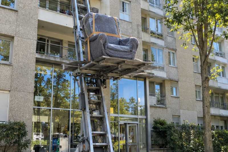 Monte-meuble déployé contre la façade, un fauteuil emballé sur la plateforme, Clichy