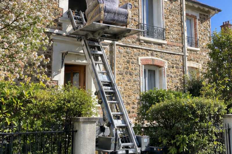 Monte-meuble déployé contre la façade, un fauteuil emballé sur la plateforme, Colombes
