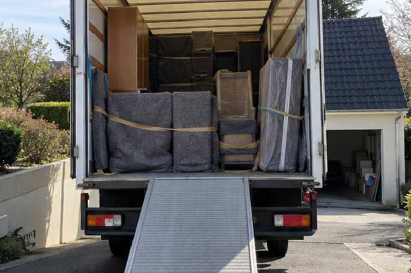 Vue arrière du camion ouvert, meubles calés sous couvertures, Mitry-Mory