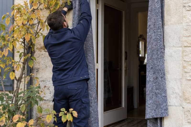 Déménageur qui protège l'encadrement de porte avec des couvertures, Val-d'Oise