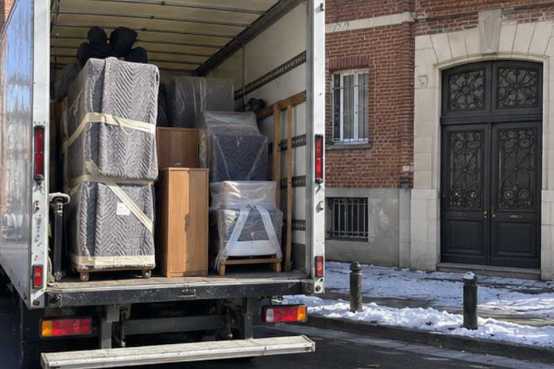 Vue arrière du camion ouvert, meubles calés sous couvertures, Vincennes